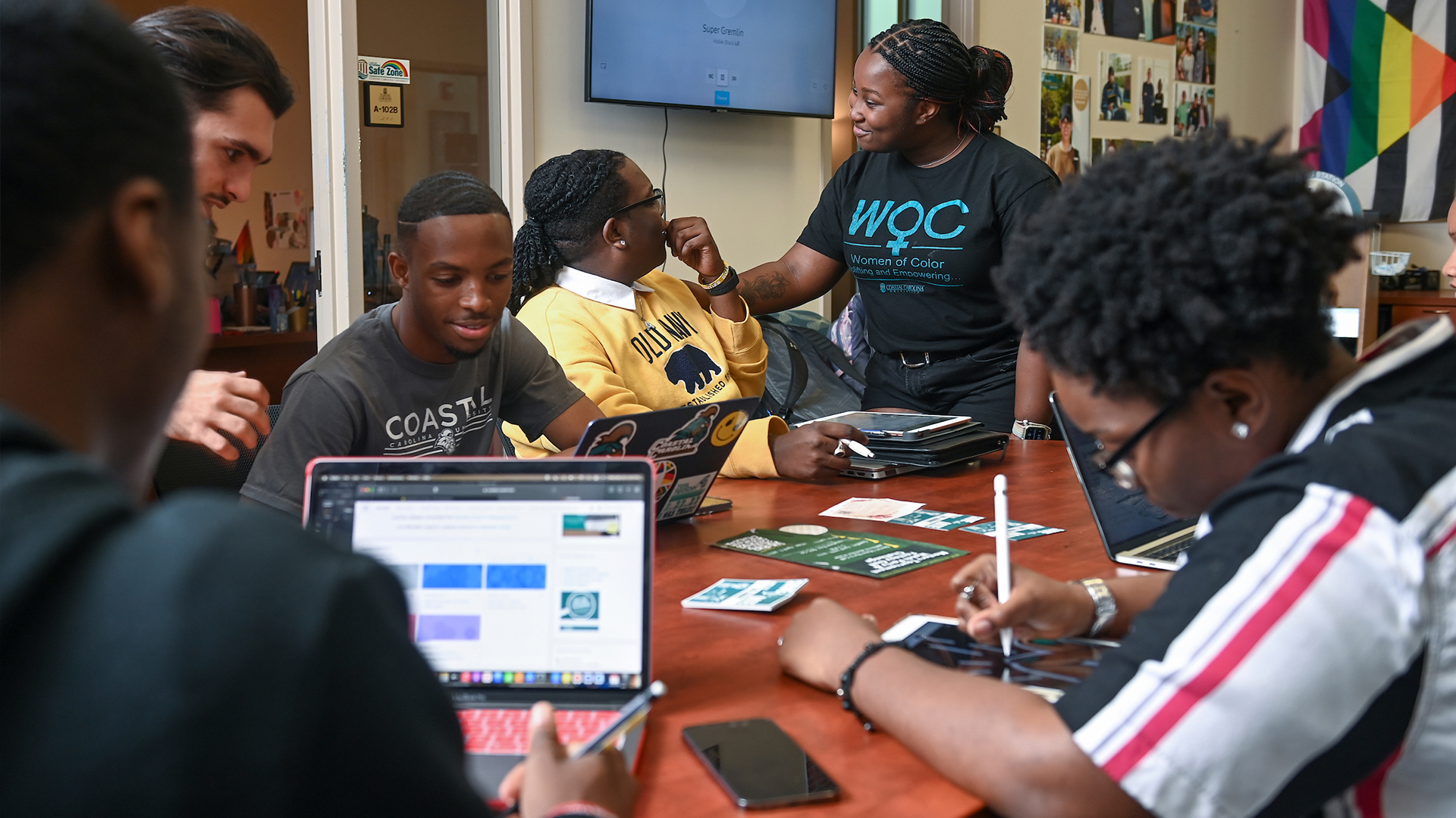 Students gather in discussion at a desk in the Intercultural and Inclusion Student Services offices