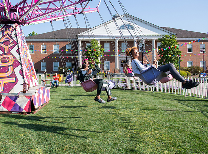 Students gather in the evening on Prince Lawn for CINO Day, in front of a giant teal carousel.