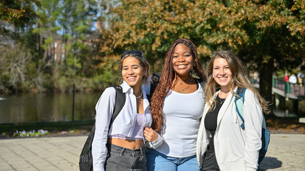 Three CCU students posing for outdoor picture near Wall Bridge