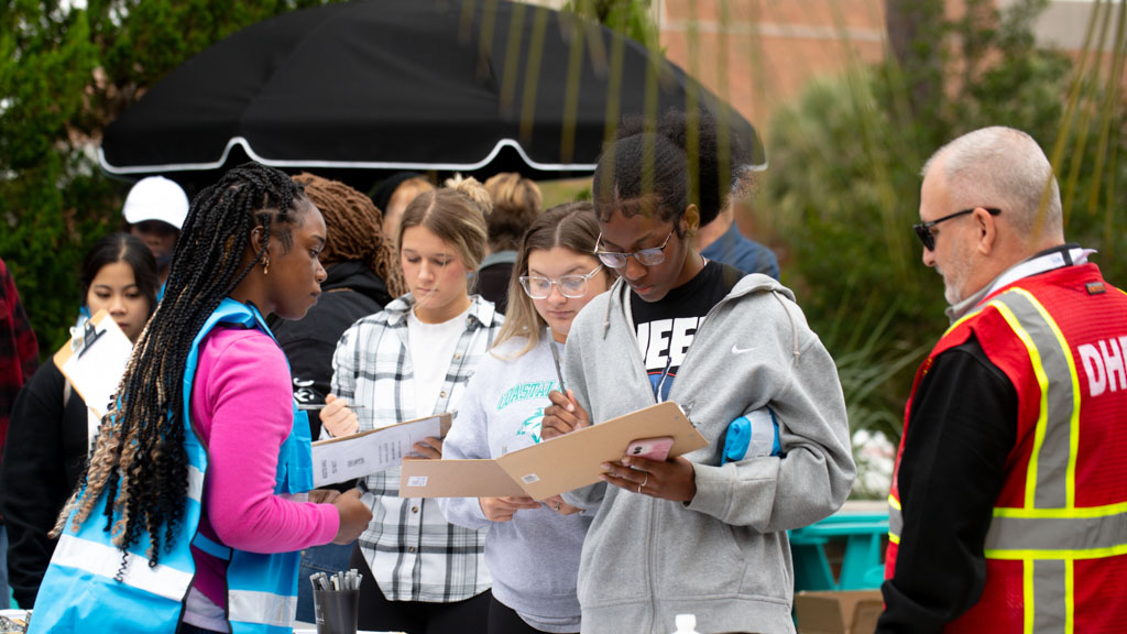 A CCU public health student helping someone fill out information at an event