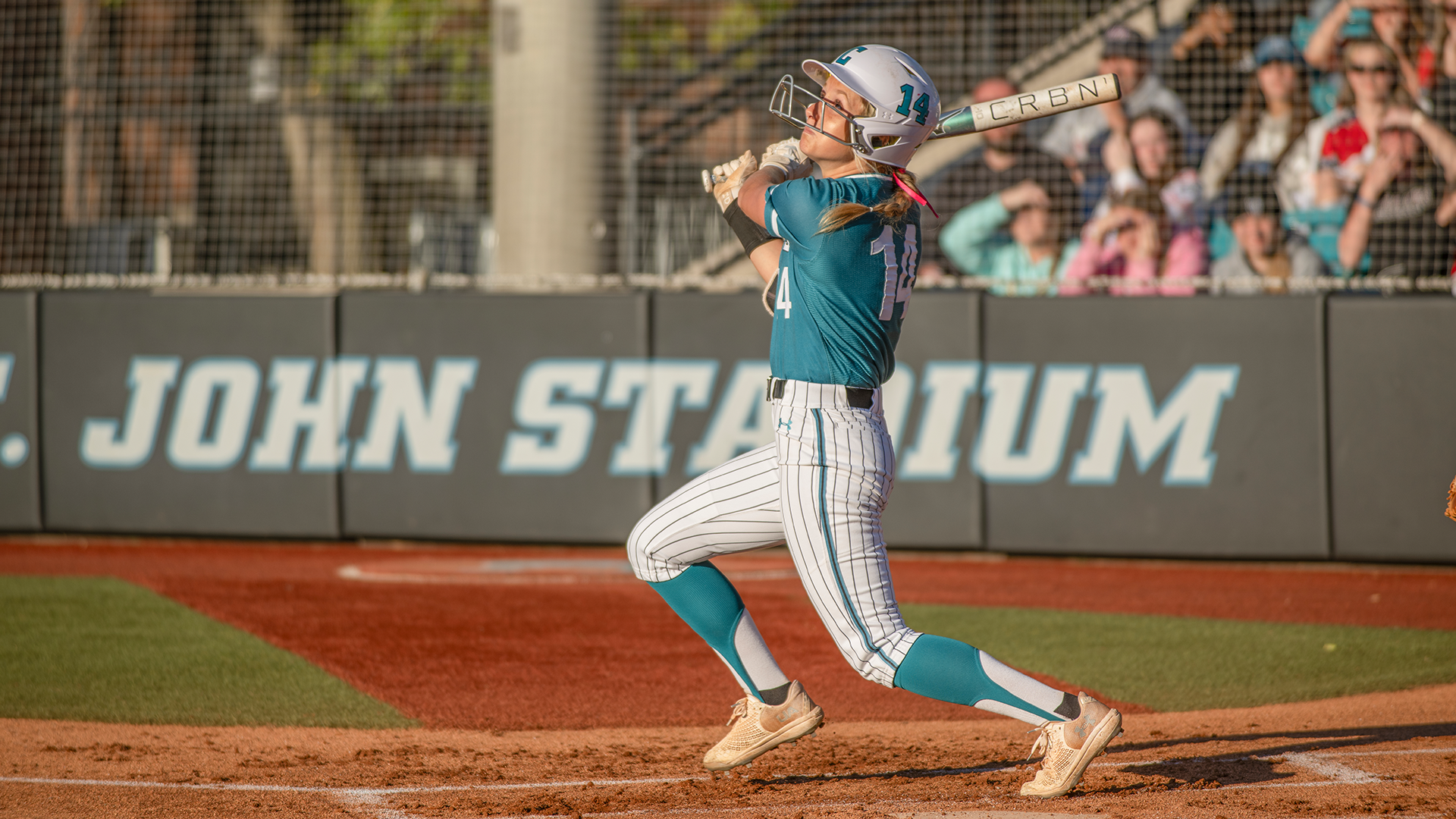 Image of student Libby Pippin hitting a softball