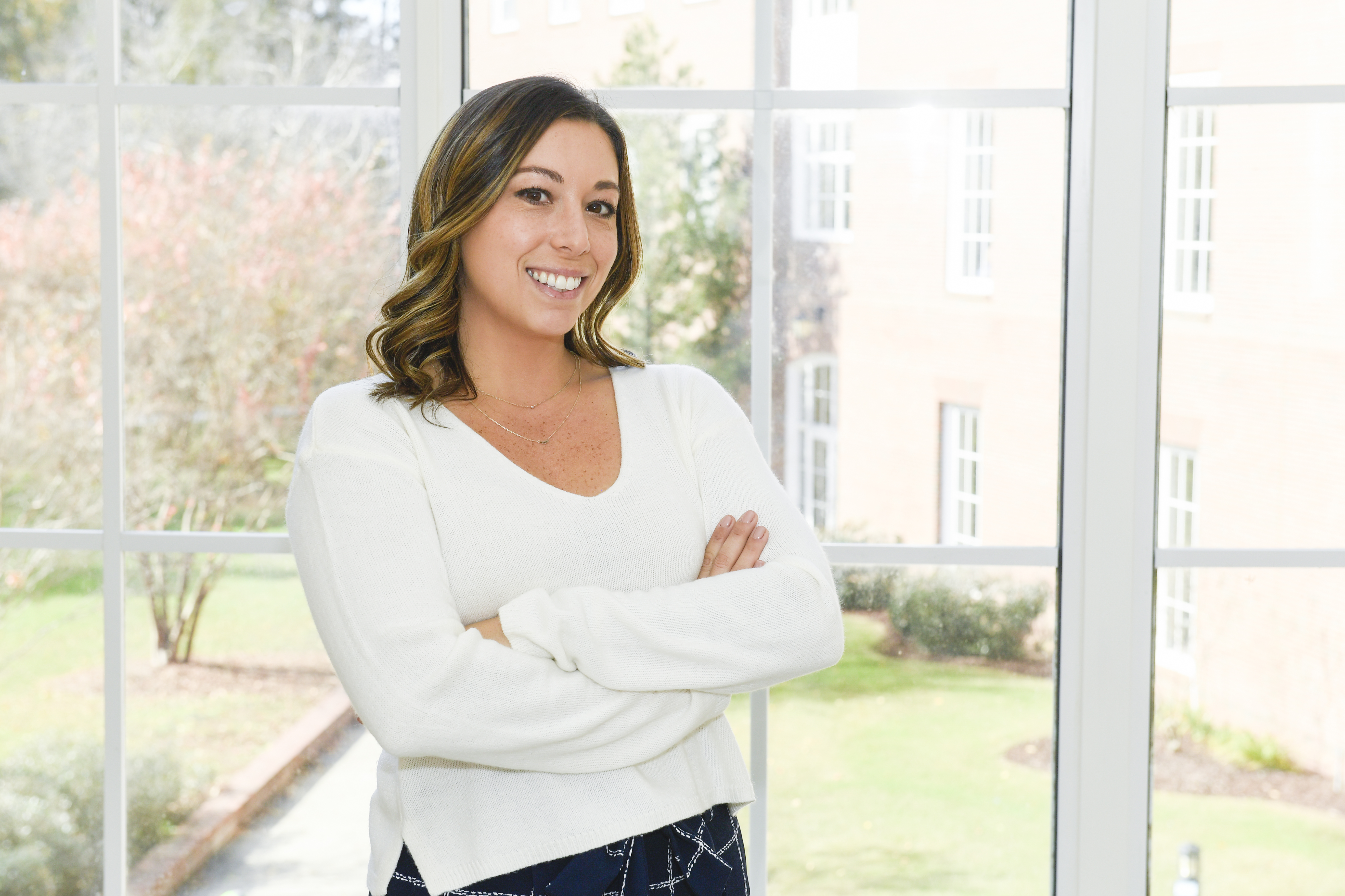 Image of alumna Michelle Russo in front of a window on Coastal Carolina University's campus