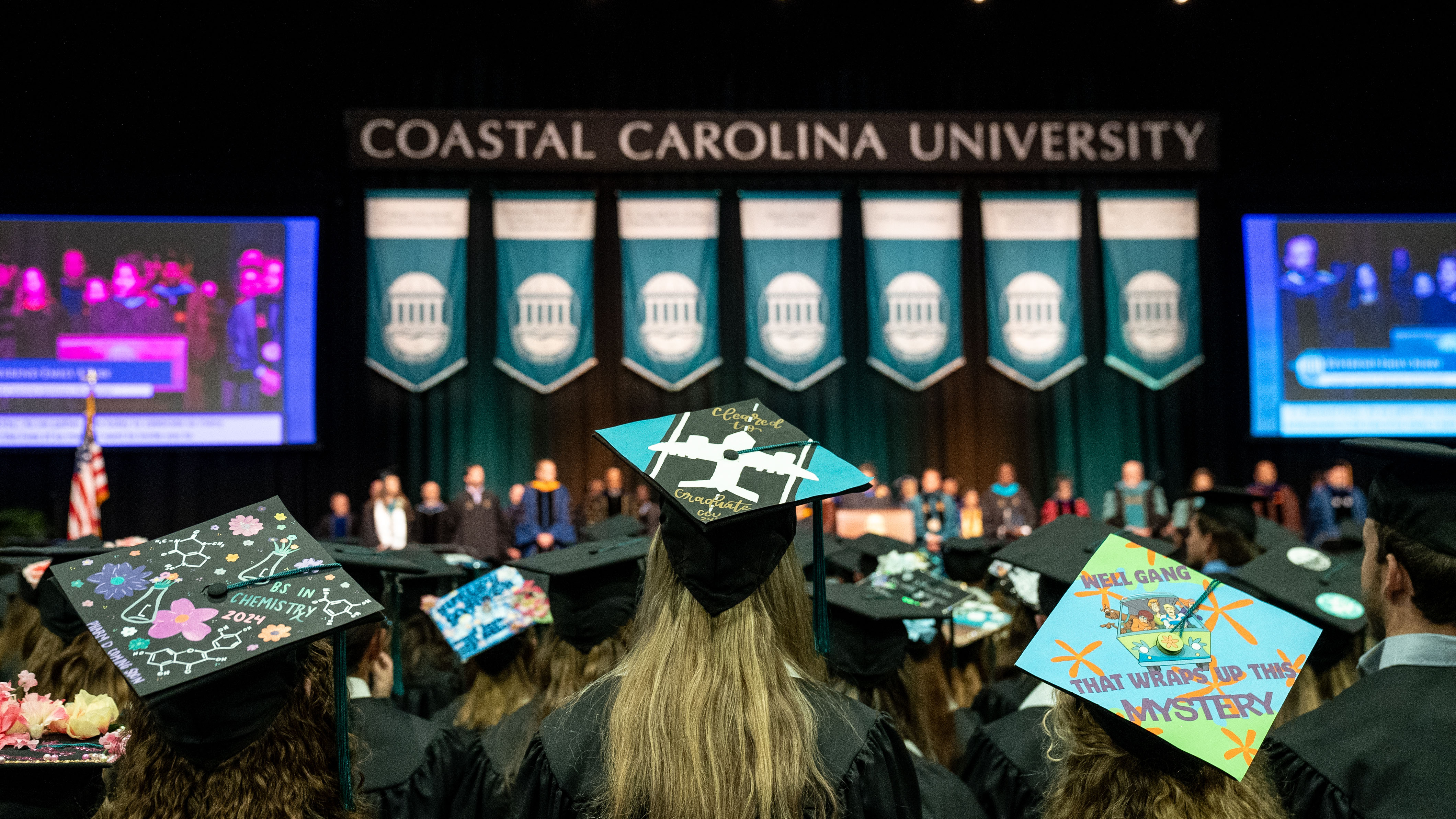 three graduates with decorated caps