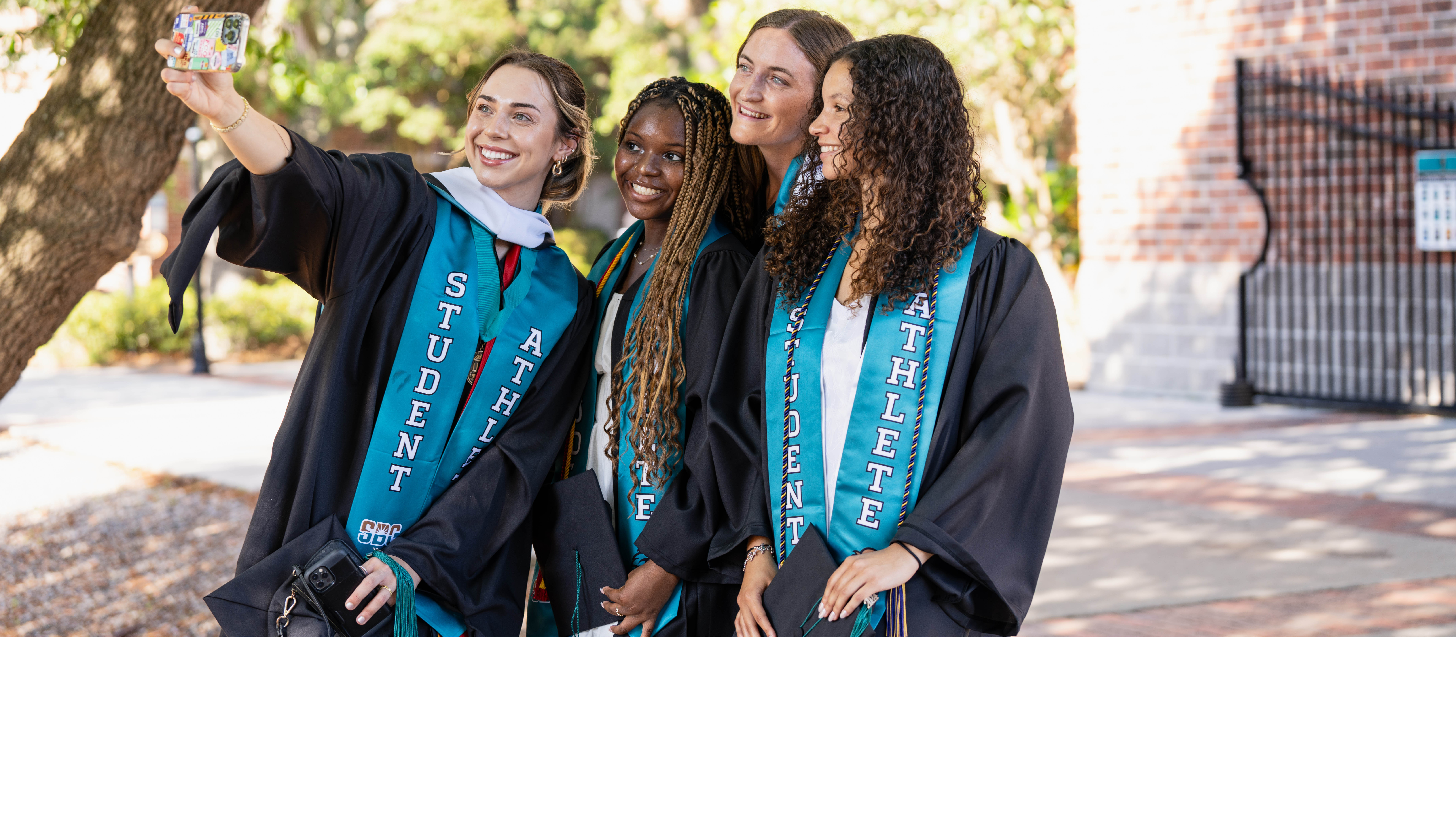 Four CCU Graduates Taking a selfie outside